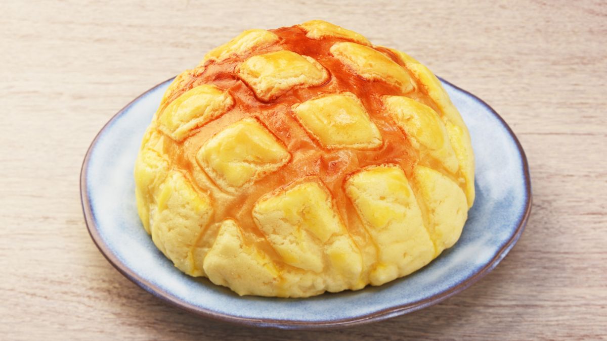 pineapple bun served ona  plate on a wooden table
